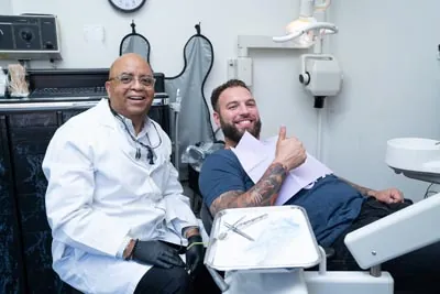 Dr. George Daniels smiling with a patient after his first dental appointment